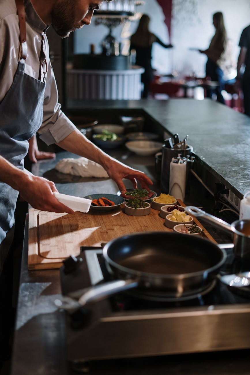 person in white apron holding white ceramic plate